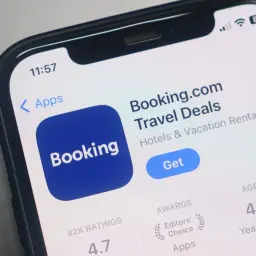 Aplikacja Booking.com na telefonie. Sprawdź, jak sprawdzić wiarygodność noclegu, analizując oceny i nagrody.